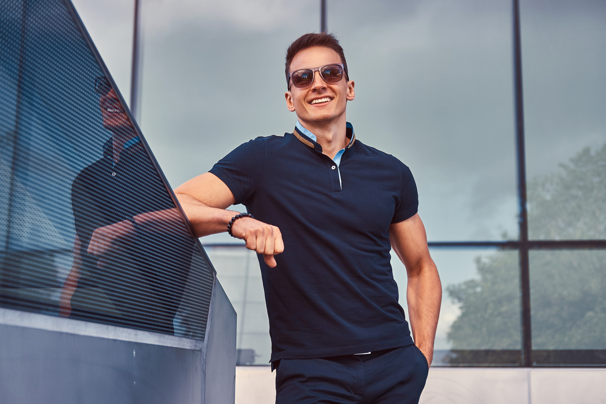 young-smiling-handsome-fashionable-man-with-stylish-haircut-sunglasses-dressed-black-t-shirt-pants-standing-modern-city-against-skyscraper (1)